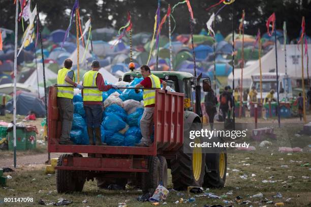 Rubbish is collected in front of the Pyramid Stage as festival goers leave the Glastonbury Festival site at Worthy Farm in Pilton on June 26, 2017...