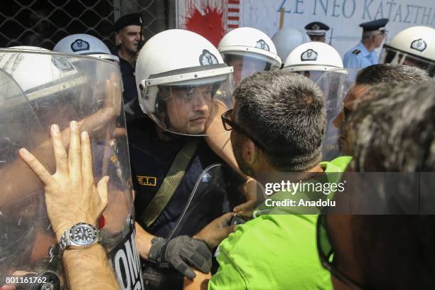 People march through the Interior Ministry as they stage a demonstration against municipalities that did not extend their contracts, at Karaiskaki...