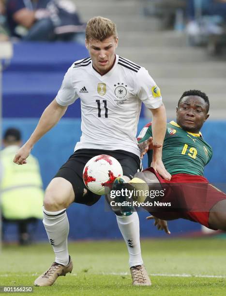 Timo Werner of Germany and Collins Fai of Cameroon vie for the ball during the first half of a Group B match at the Confederations Cup in Sochi,...