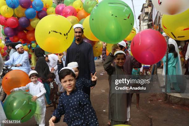 Pakistani kids play with balloons as they leave a mosque after the Eid al-Fitr prayer in Karachi, Pakistan on June 26 ,2017. Eid al-Fitr is a...