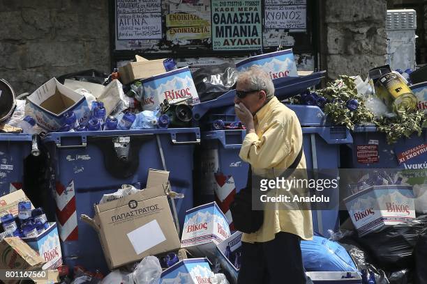 Fully loaded garbage cans are seen as cleaning workers attend a demonstration against municipalities that did not extend their contracts in Athens,...