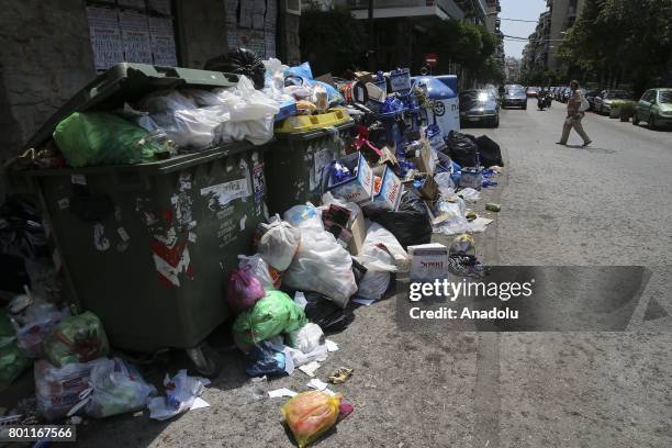 Fully loaded garbage cans are seen as cleaning workers attend a demonstration against municipalities that did not extend their contracts in Athens,...