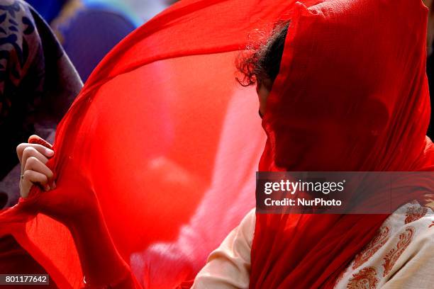 Sri Lankan muslim girl adjusts her veil that blows in the wind as she prays during Eid al-Fitr prayers to mark the end of the holy fasting month of...