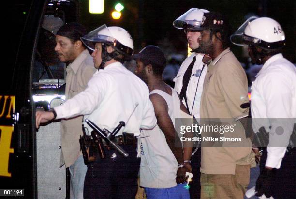 : Police officers arrest three African Americans for being outside after an 8pm curfew April 12, 2001 in Cincinnati, OH. The city is reeling from...