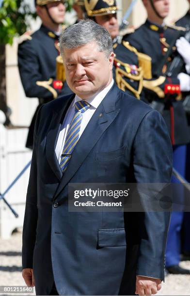 Ukrainian President Petro Poroshenko walks past the honor guard prior to a meeting with French President Emmanuel Macron at the Elysee Presidential...