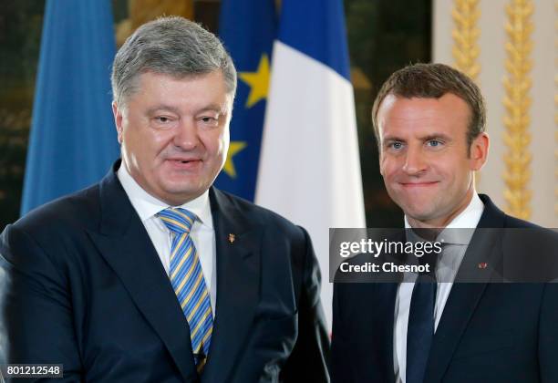 French President Emmanuel Macron shakes hands with Ukrainian President Petro Poroshenko after a joint press conference at the Elysee Presidential...