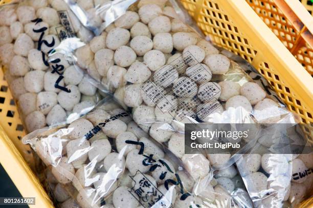 editorial use: konnyaku jelly in bags piled in plastic box - konjak stockfoto's en -beelden