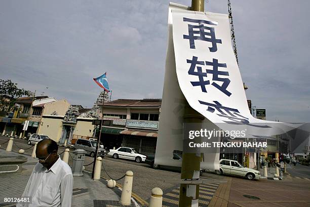 Malaysia-vote-Chinese by M. Jegathesan A pedestrian walks past a Chinese-language campaign banner for the ruling Barisan Nasional coalition in...