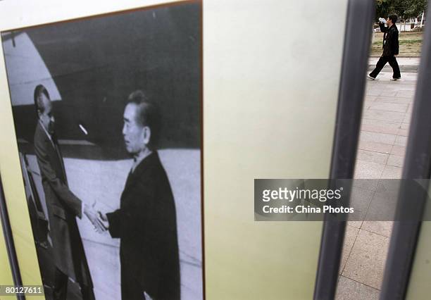 Visitor walks past a photo showing late Chinese premier Zhou Enlai meeting with former US President Richard Milhous Nixon during a photo exhibition...