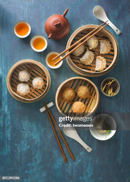 flat lay traditional chinese food dim sum on blue rustic table top. - dim sum stockfoto's en -beelden