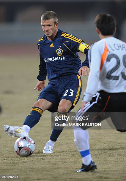 English football star David Beckham from the LA Galaxy team, takes on opponent Chan Yiu Lun during their exhibition match against a joint...