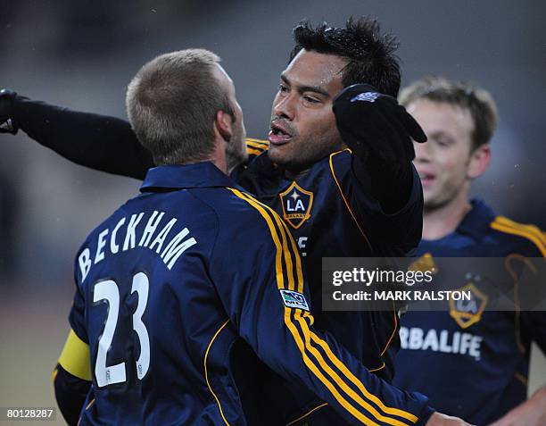 English football star David Beckham from the LA Galaxy team, celebrates with teammate Ruiz after assisting a goal during their exhibition match...
