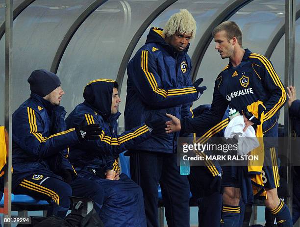 English football star David Beckham from the LA Galaxy team, is greeted by Abel Xavier and other teammates as he returns to the bench after he was...