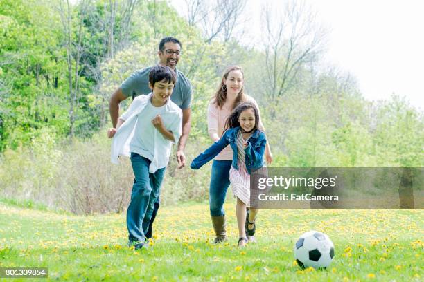 cute family playing soccer at the park - indian football stock pictures, royalty-free photos & images