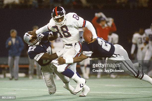Wide receiver Bobby Johnson of the New York Giants tries to elude defensive backs Ron Fellows and Everson Walls of the Dallas Cowboys at Giants...