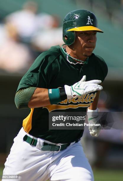 Carlos Gonzalez of the Oakland Athletics runs to first base during the spring training game against the Milwaukee Brewers at Phoenix Municipal...