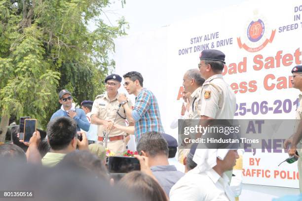 Bollywood actor Siddharth Malhotra along with DCP Traffic AK Singh and school children participates during a Delhi road safety activity to spread...