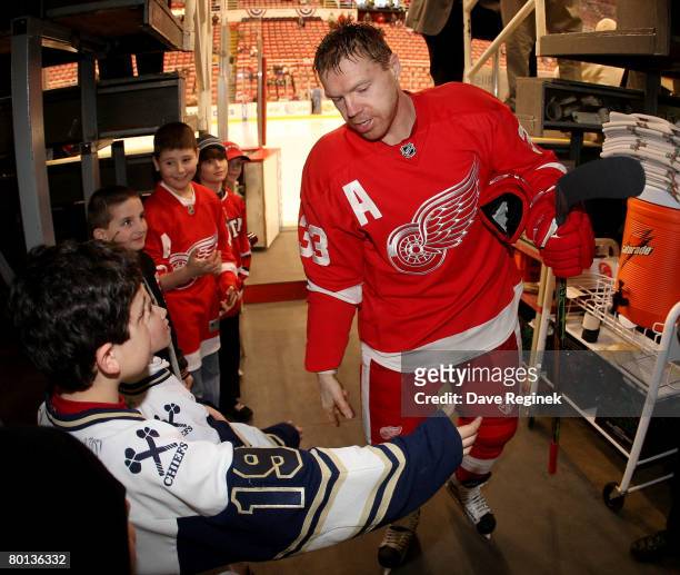 Kris Draper of the Detroit Red Wings greets some young fans before the NHL game against the St. Louis Blues on March 5, 2008 at Joe Louis Arena in...