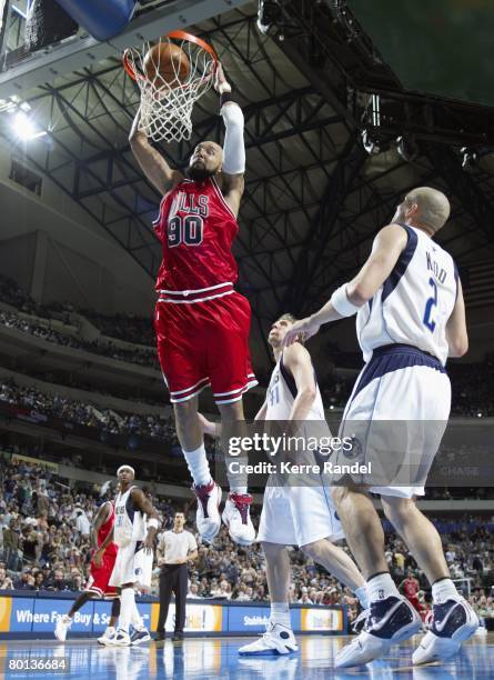 Drew Gooden of the Chicago Bulls dunks against Dirk Nowitzki and Jason Kidd of the Dallas Mavericks during the game at the American Airlines Center...