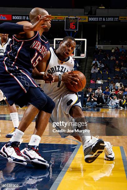 Kyle Lowry of the Memphis Grizzlies drives around Vince Carter of the New Jersey Nets on March 5, 2008 at the FedExForum in Memphis, Tennessee. NOTE...