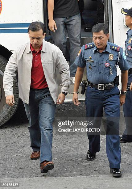 Senator and ex-navy lieutenant Antonio Trillanes handcuffed to a guard arrives for a court hearing in the financial district Makati suburban Manila...