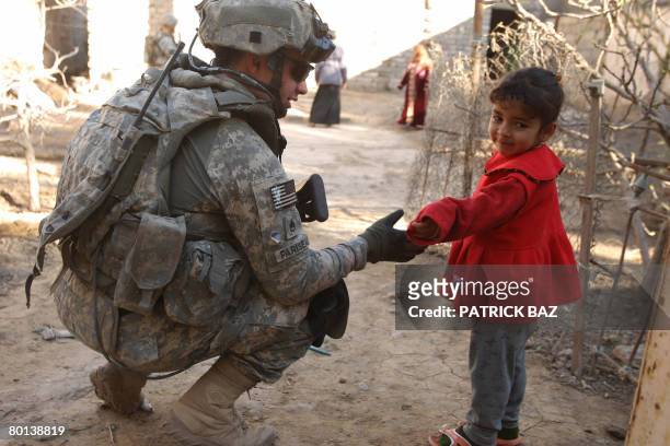 Army sergeant with A company 4th Battallion 9th Infantry Regiment 4th Stryker Brigade Combat Team chats with an Iraqi girl during a patrol in Baquba...