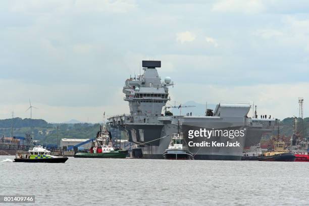 The aircraft carrier HMS Queen Elizabeth leaves Rosyth dockyard to begin sea trials before entering service with the fleet, on June 26, 2017 in...