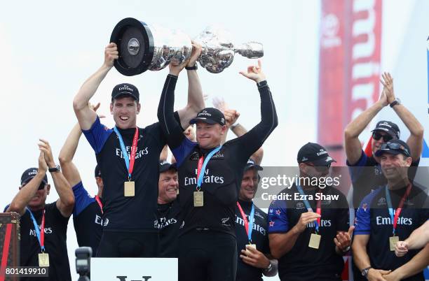 Emirates Team New Zealand helmsman Peter Burling and skipper Glenn Ashby receive the "Auld Mug" trophy after winning the America's Cup Match...