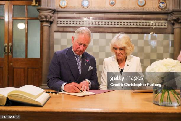 Prince Charles, Prince of Wales and Camilla, Duchess of Cornwall sign a book of condolence after a reception in Manchester Town Hall to thank those...