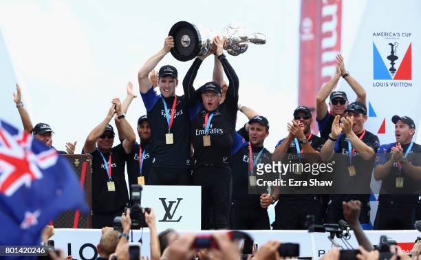 Emirates Team New Zealand helmsman Peter Burling and skipper Glenn Ashby receive the "Auld Mug" trophy after winning the America's Cup Match...