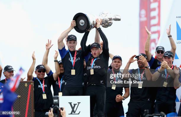 Peter Burling and Glenn Ashby of Emirates Team New Zealand lift the America's Cup trophy after they beat ORACLE TEAM USA on June 26, 2017 in...