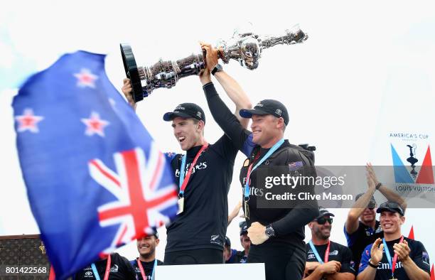 Peter Burling and Glenn Ashby of Emirates Team New Zealandlift the trophy after winning race 9 against Oracle Team USA to win the America's Cup on...