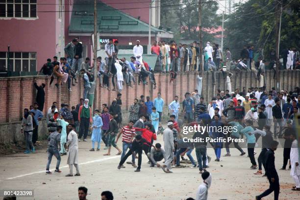 Kashmiri protesters pelting stones to the police officers and paramilitary soldiers after the culmination of 'Eid-ul-Fitr congregational prayer....