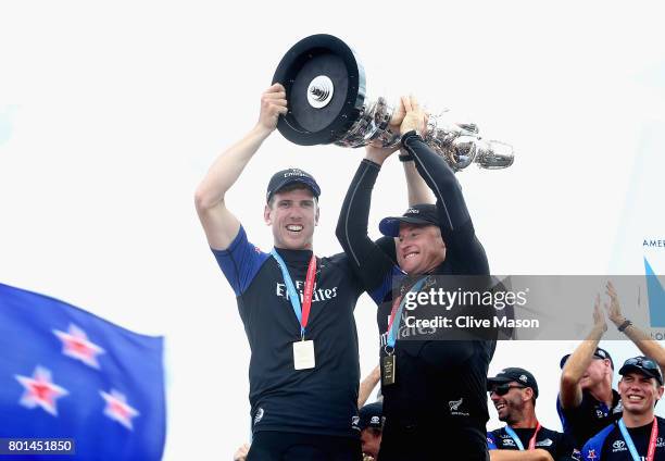 Peter Burling and Glenn Ashby of Emirates Team New Zealandlift the trophy after winning race 9 against Oracle Team USA to win the America's Cup on...