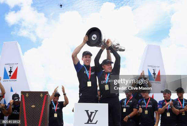 Peter Burling and Glenn Ashby of Emirates Team New Zealandlift the trophy after winning race 9 against Oracle Team USA to win the America's Cup on...