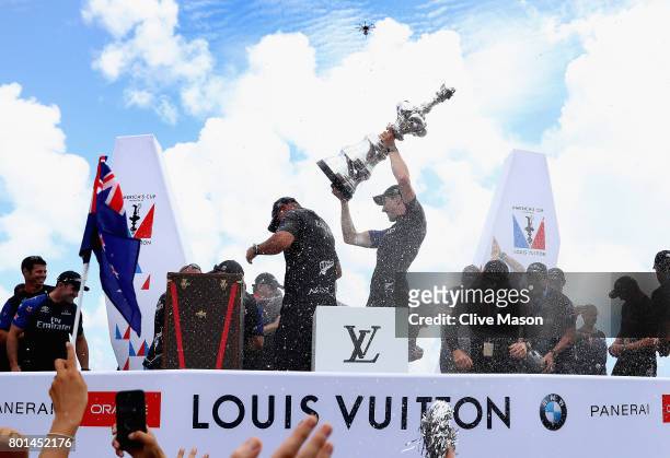 Peter Burling, helmsman of Emirates Team New Zealand, lifts the trophy after winning race 9 against Oracle Team USA to win the America's Cup on day 5...