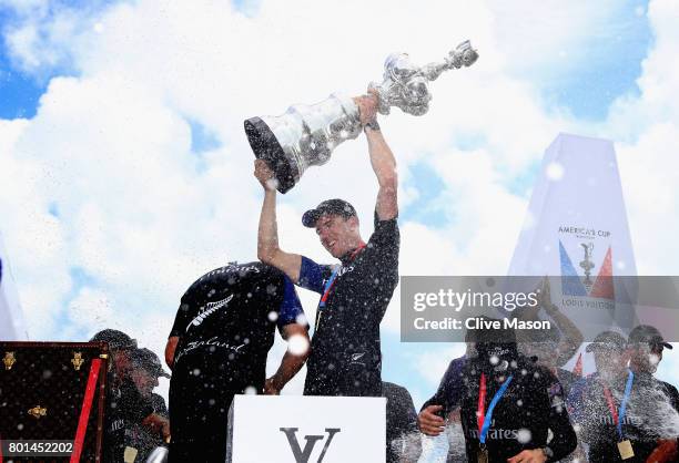 Peter Burling, helmsman of Emirates Team New Zealand, lifts the trophy after winning race 9 against Oracle Team USA to win the America's Cup on day 5...