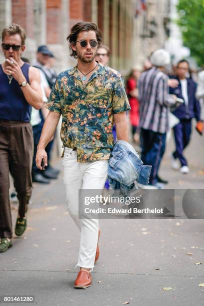 Guest wears a flower print shirt, white pants, brown shoes,outside the Paul Smith show, during Paris Fashion Week - Menswear Spring/Summer 2018, on...