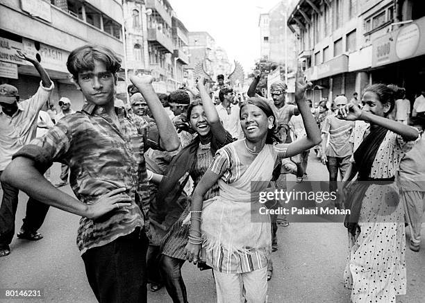 Devotees of the elephant god Ganesha dance in the streets as they carry statues of the deity to be immersed in the water October 2002 in Mumbai,...
