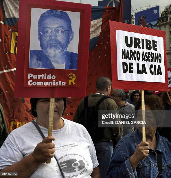 Demonstrators carry a portrait of the number two leader of the Marxist FARC rebels, Raul Reyes, and a poster against Colombian president Alvaro Uribe...