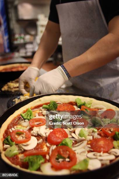 Carlos Guzman prepares a deep dish pizza at Connie's Pizza on March 6, 2008 in Chicago, Illinois. The cost of flour, a key ingredient in making pizza...