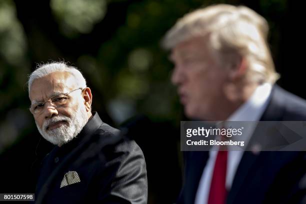 Narendra Modi, India's prime minister, left, listens as U.S. President Donald Trump, speaks during a joint statement in the Rose Garden of the White...
