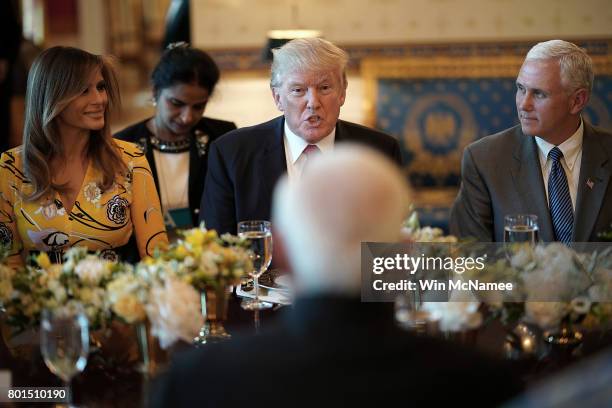 President Donald Trump , flanked by first lady Melania Trump and Vice President Mike Pence , delivers remarks before dinner with Indian Prime...