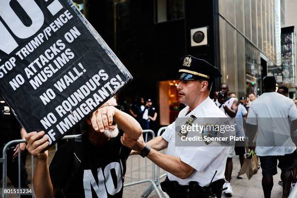 Protester scuffles with a police officer outside of Trump Tower following an announcment by the Supreme Court that it will take President Donald...