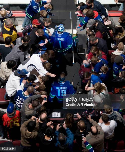 Roberto Luongo and Markus Naslund of the Vancouver Canucks are surrounded by fans as they walk onto the ice before their game against the Nashville...