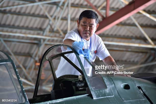 This picture taken on June 9, 2017 shows Japanese pilot Kazuaki Yanagida preparing a restored World War II-era Mitsubishi A6M Type 22 Zero fighter...