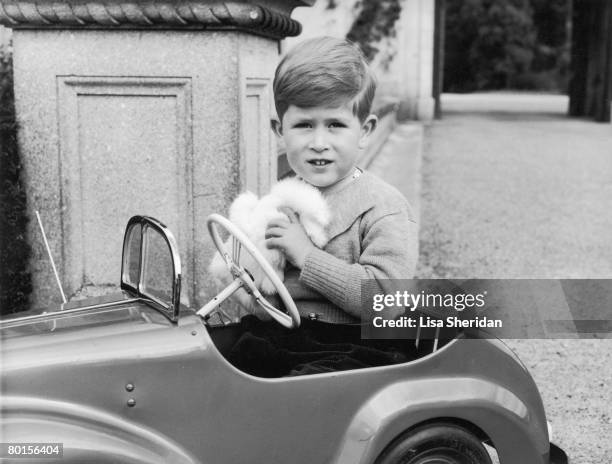 Prince Charles plays in a miniature car in the grounds of Balmoral Castle, Scotland, September 1952.