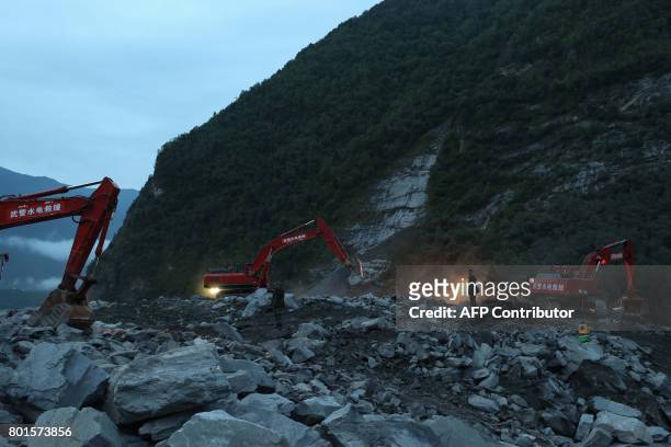 In this photo taken on June 25 rescue workers are seen at the site of a landslide in Xinmo village, Diexi town of Maoxian county, Sichuan province....