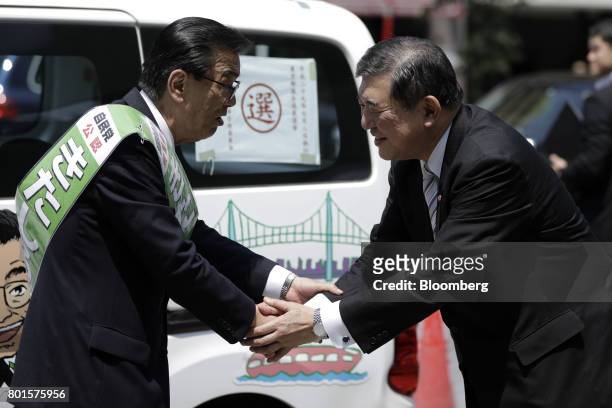 Shigeru Ishiba, a member of the Liberal Democratic Party and the House of Representatives, right, shakes hands with Katsuhiko Kitashiro, left, a...