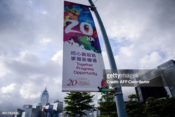 In this photo taken on June 26 a banner commemorating the 20th anniversary of Hong Kong's handover from British to Chinese rule is displayed near the...